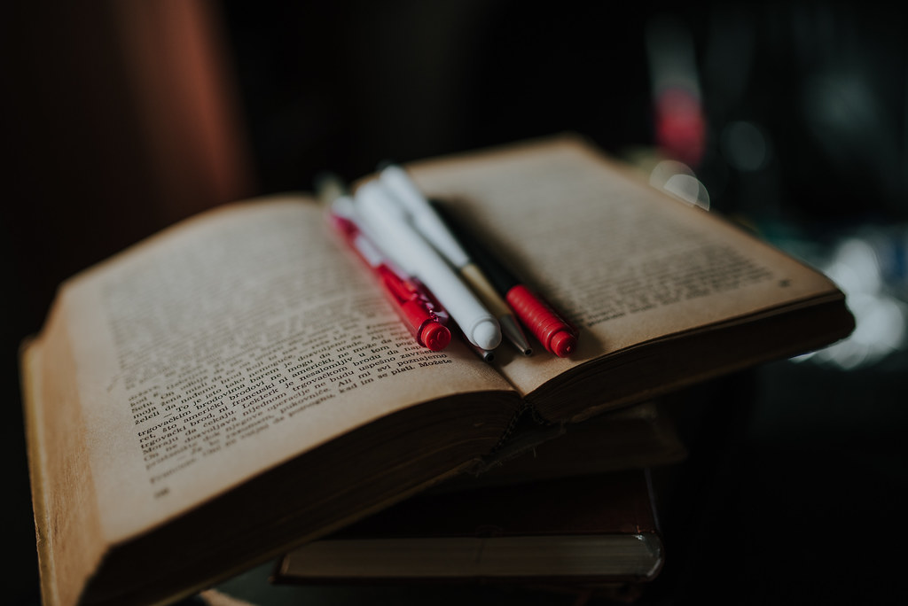 Opengeslagen oud boek met warm licht – over ons sectie